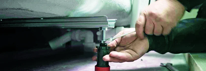 Person montiert Badewanne mit Schraubenschlüssel.