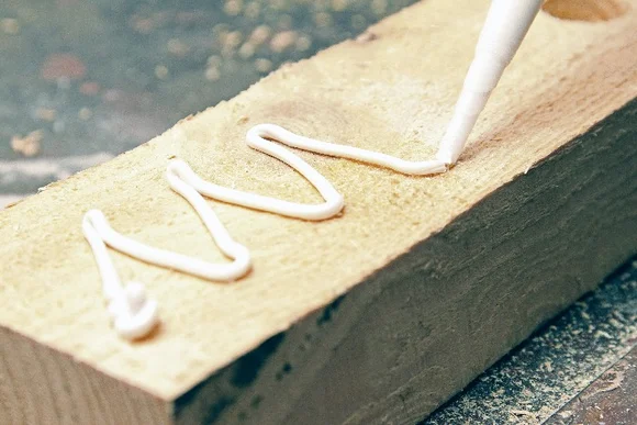 Klebstoff wird auf Holz aufgetragen