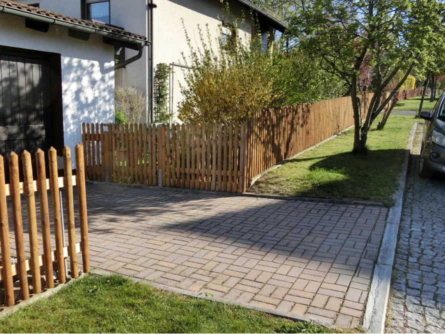Holzzaun und gepflasterte Auffahrt