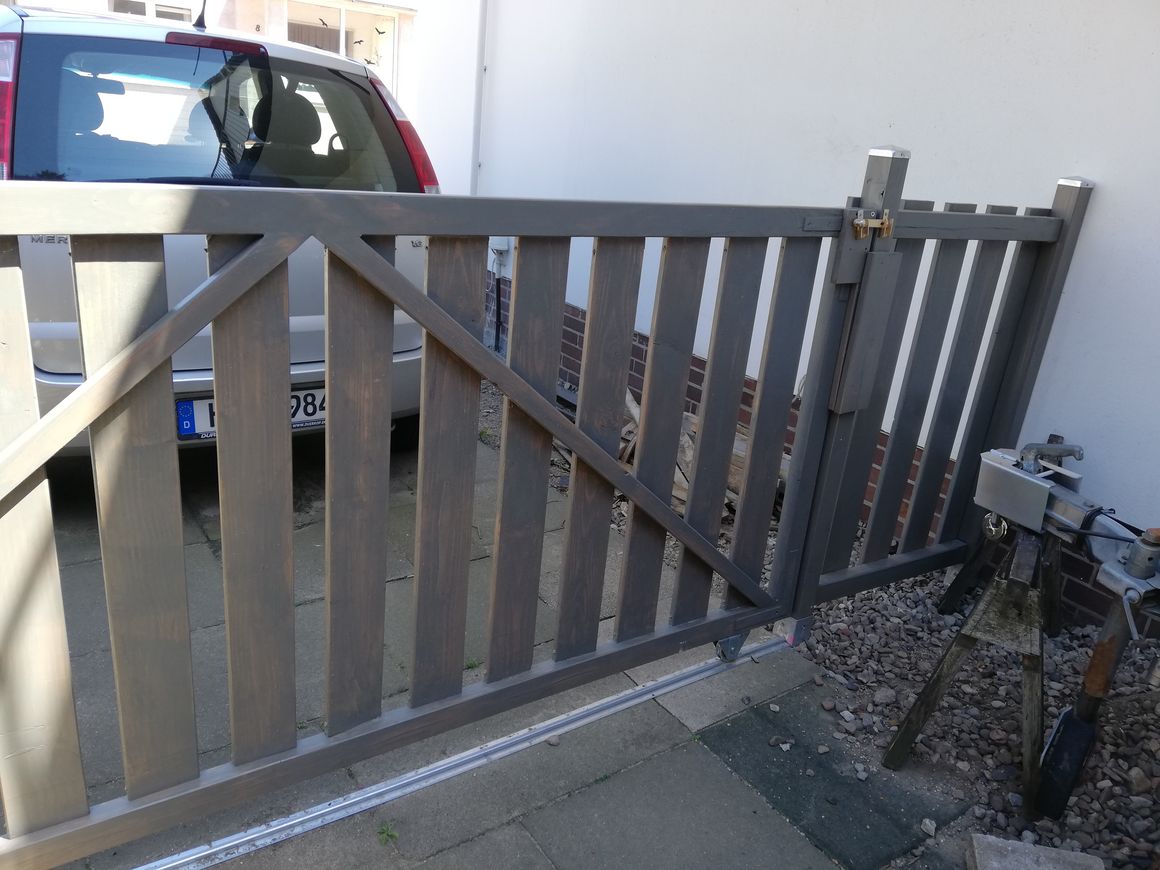 Graues Holztor mit diagonaler Strebe