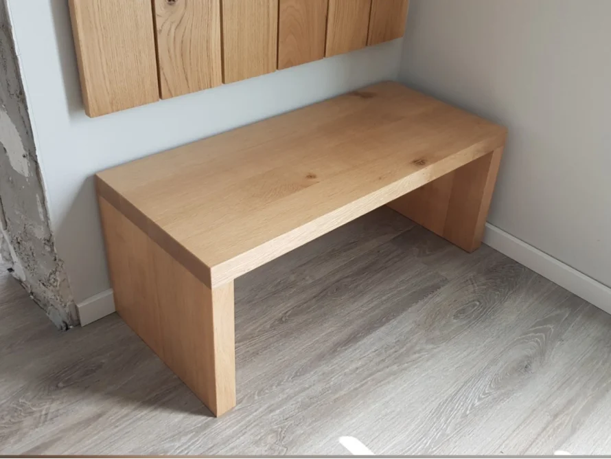 Eine einfache Holzbank in einem Flur.