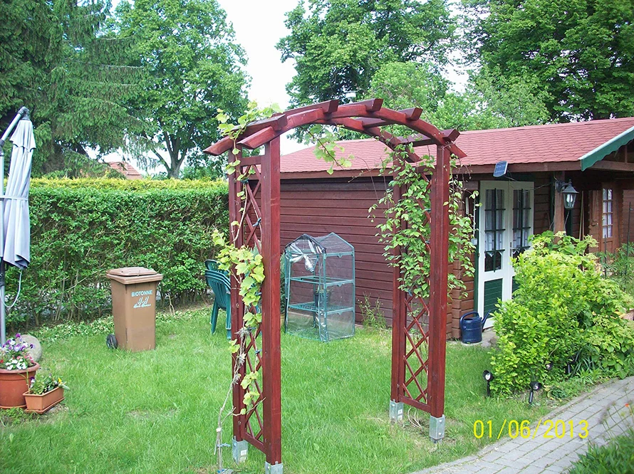 Gartenlaube mit Rankbogen im Garten