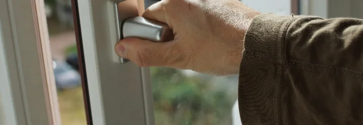 Hand öffnet Fenstergriff