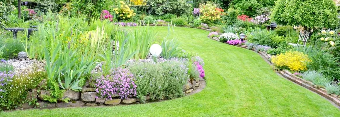 Gepflegter Garten mit Rasenfläche und Blumenbeeten