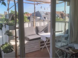 Sonniger Balkon mit Sitzecke und Pflanzen