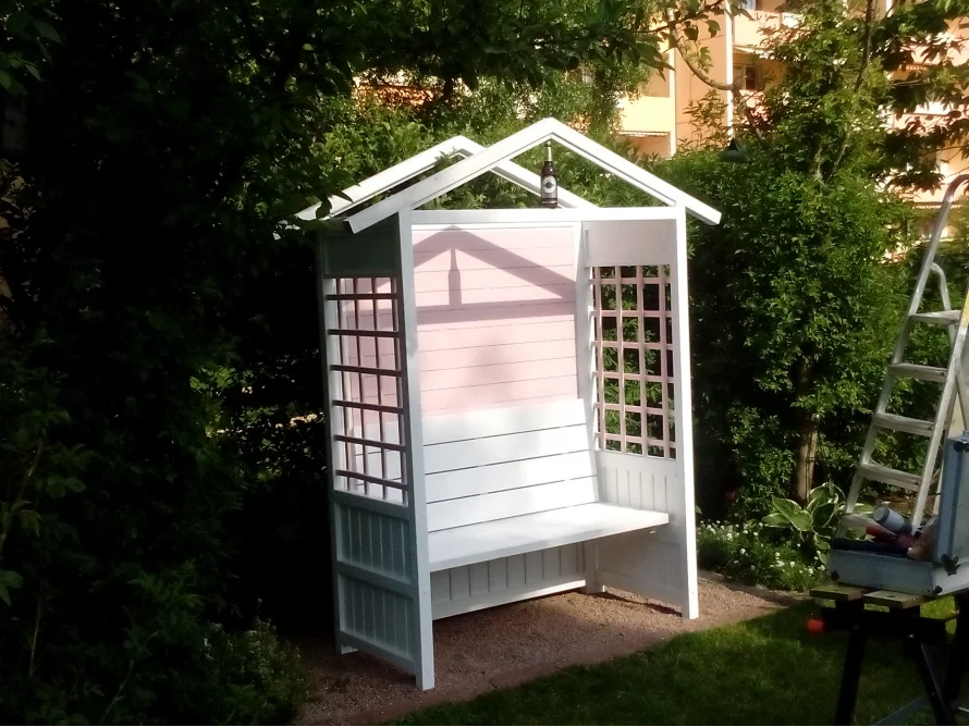 Weißes Gartenhäuschen mit rosa Dach