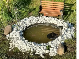 Runder Gartenteich mit Springbrunnen und Solarlampen