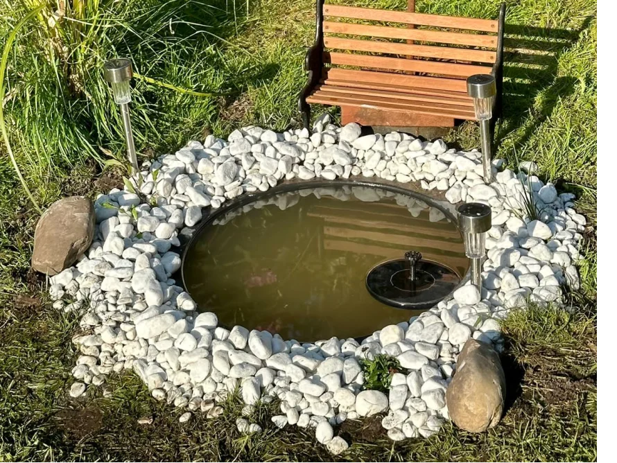 Runder Gartenteich mit Springbrunnen und Solarlampen