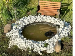 Runder Gartenteich mit Springbrunnen und Solarlampen
