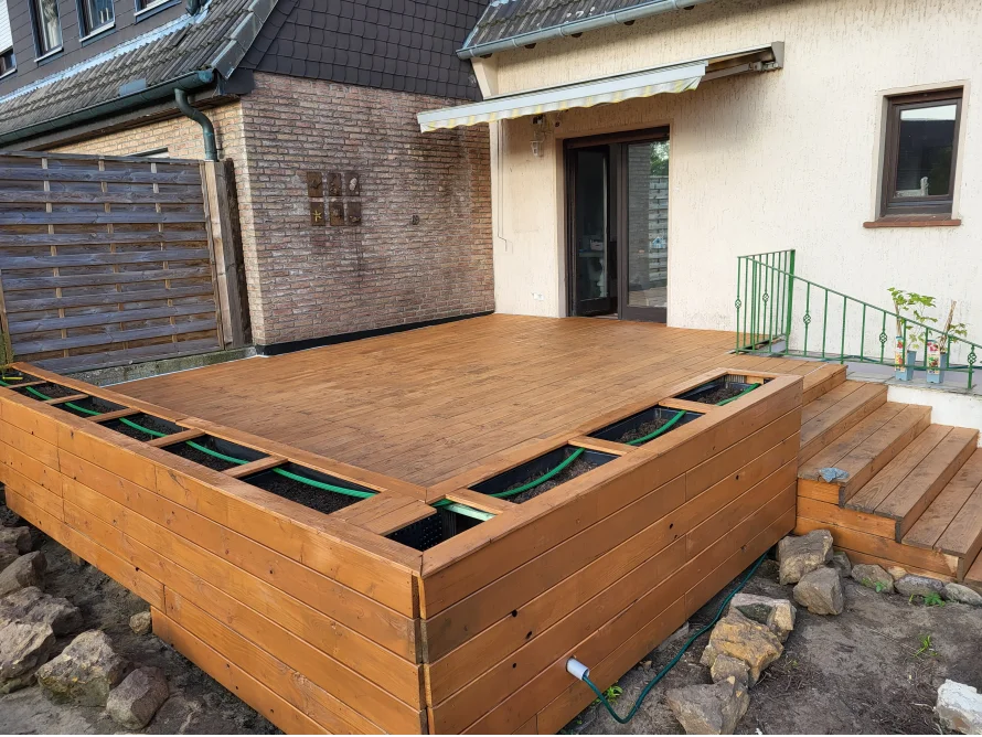 Holzterrasse mit Hochbeeten