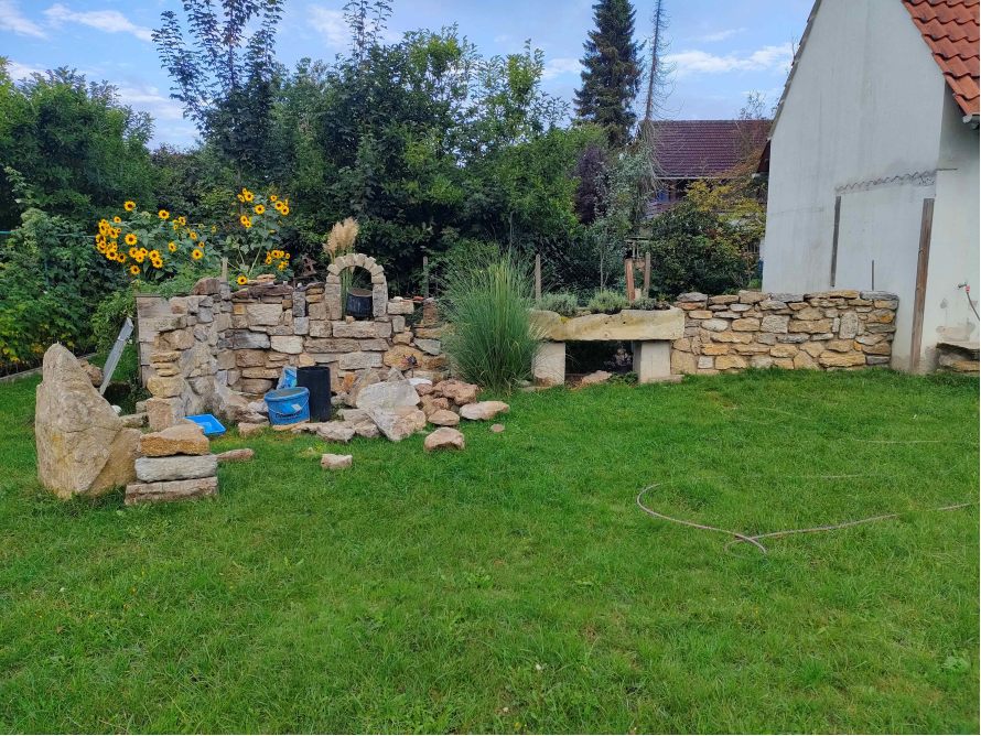 Unfertige Natursteinmauer im Garten