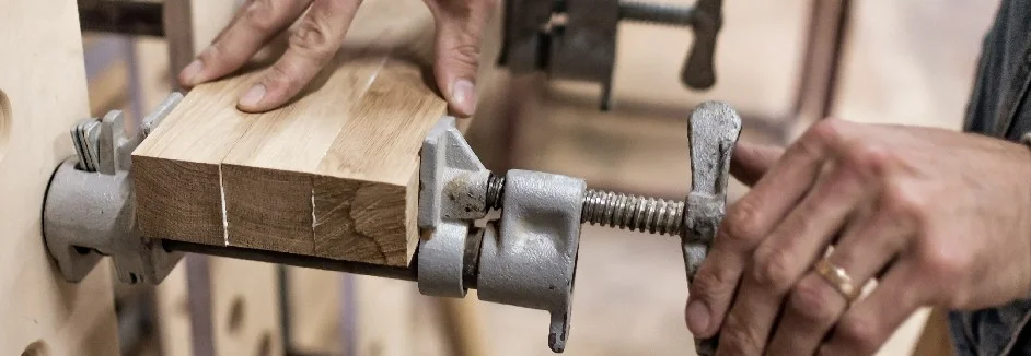 Person setzt Schraubzwinge an