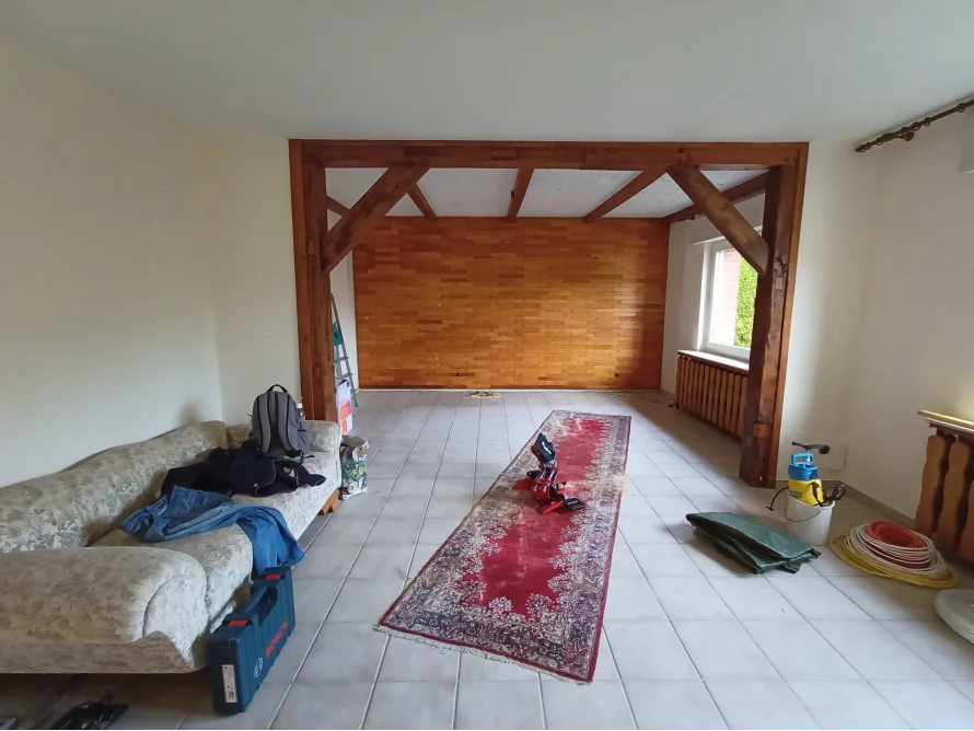 Wohnzimmer mit freigelegtem Gebälk während Renovierung