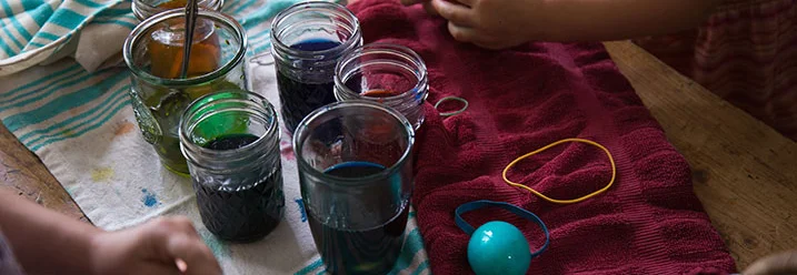 Person färbt Ostereier mit Farbe