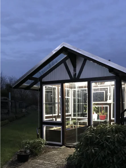 Beleuchtetes Gartenhaus in der Dämmerung