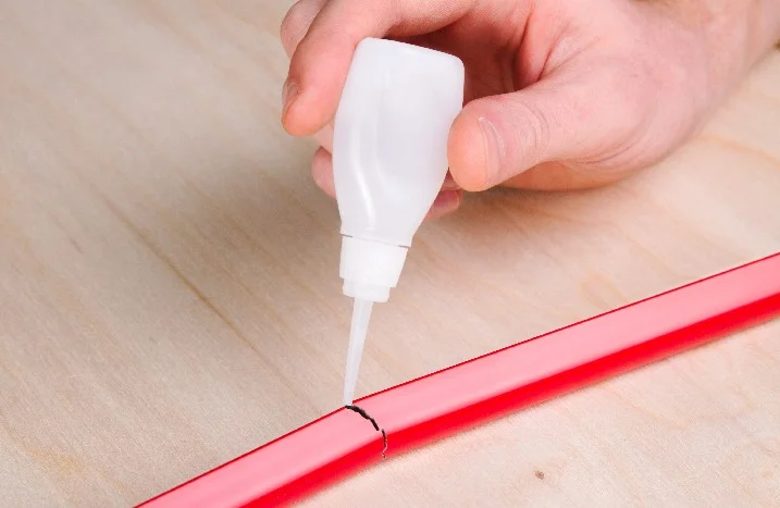Kleber wird auf ein Rohr aufgetragen