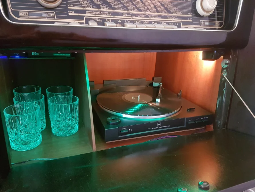 Ein altes Radio mit eingebautem Plattenspieler und Gläsern