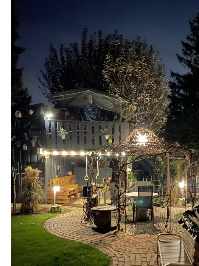 Gemütlicher Garten mit beleuchtetem Baumhaus und Sitzecke