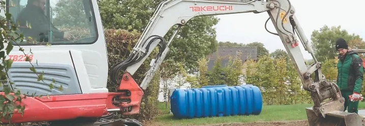 Ein Bagger hebt eine Grube in einem Garten aus.