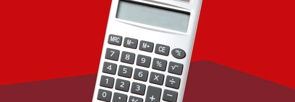 Ein silberner Taschenrechner vor rotem Hintergrund.