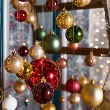 Weihnachtskugeln in verschiedenen Farben hängen von Fäden