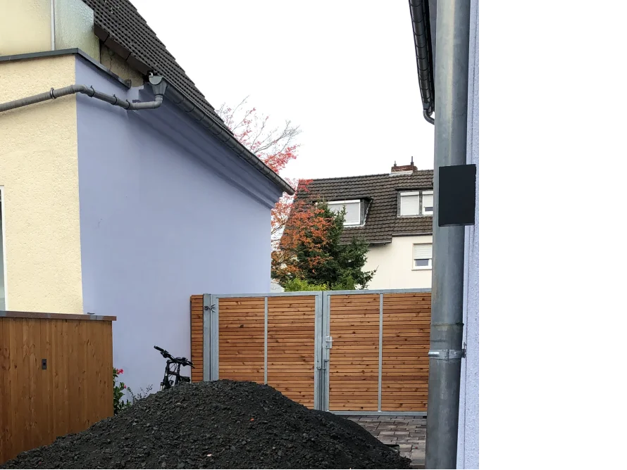 Ein Haufen Kies vor einem Holzzaun.