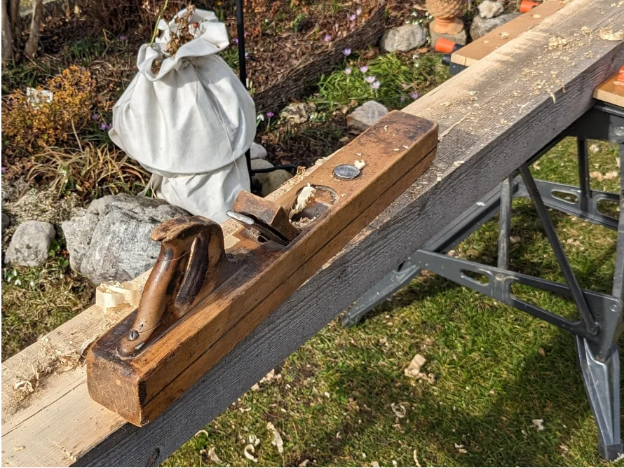 Hobel auf einem Holzbalken