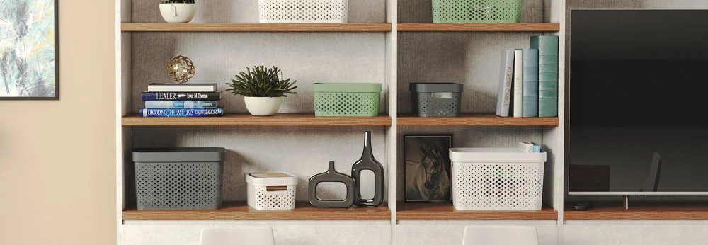 Ein weißes Regal mit Aufbewahrungsboxen und Deko.