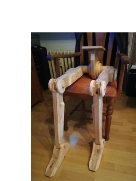 Eine Holzpuppe in Form eines Roboters sitzt auf einem Stuhl.