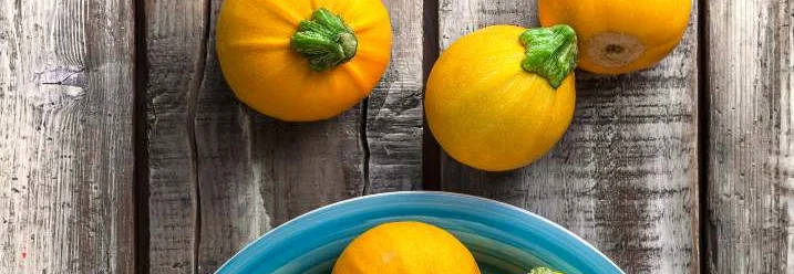 Gelbe Zucchini auf Holztisch