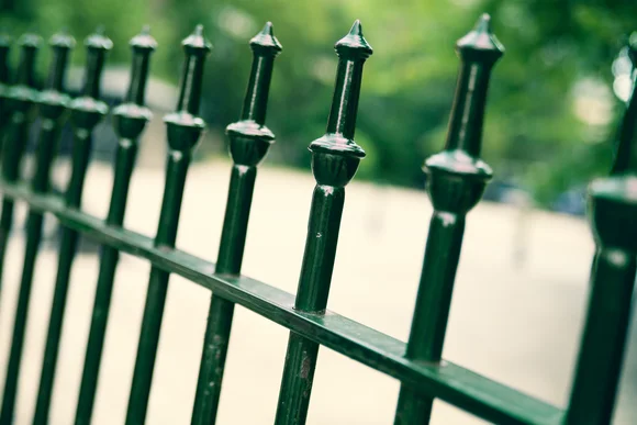 Nahaufnahme eines grünen Metallzauns