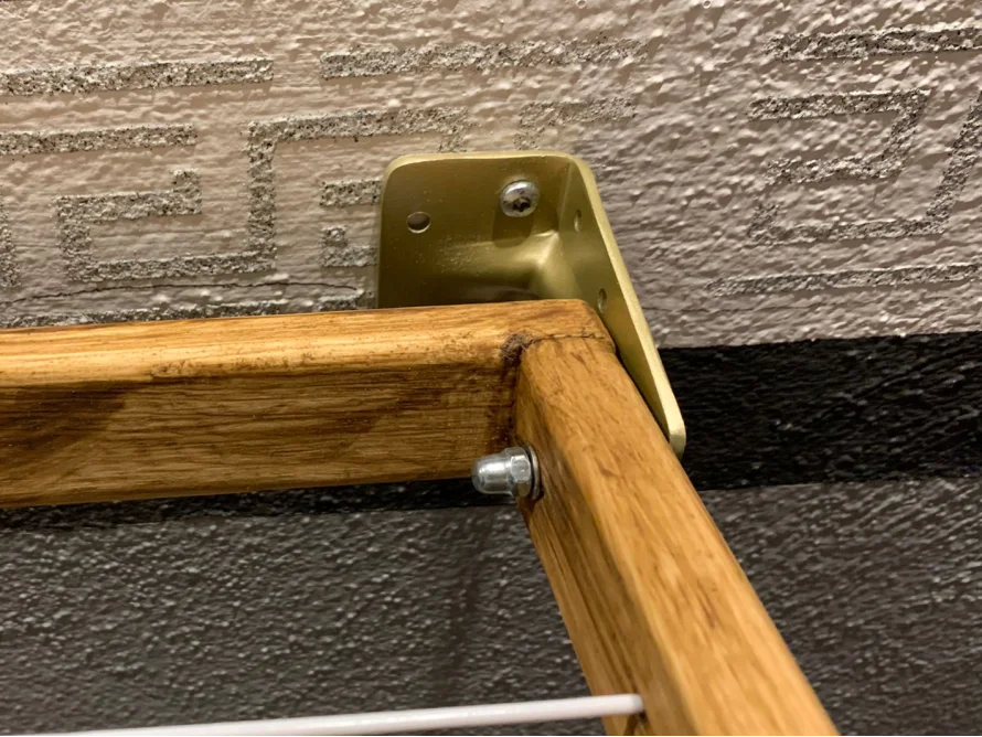 Goldene Winkelhalterung an Holzrahmen