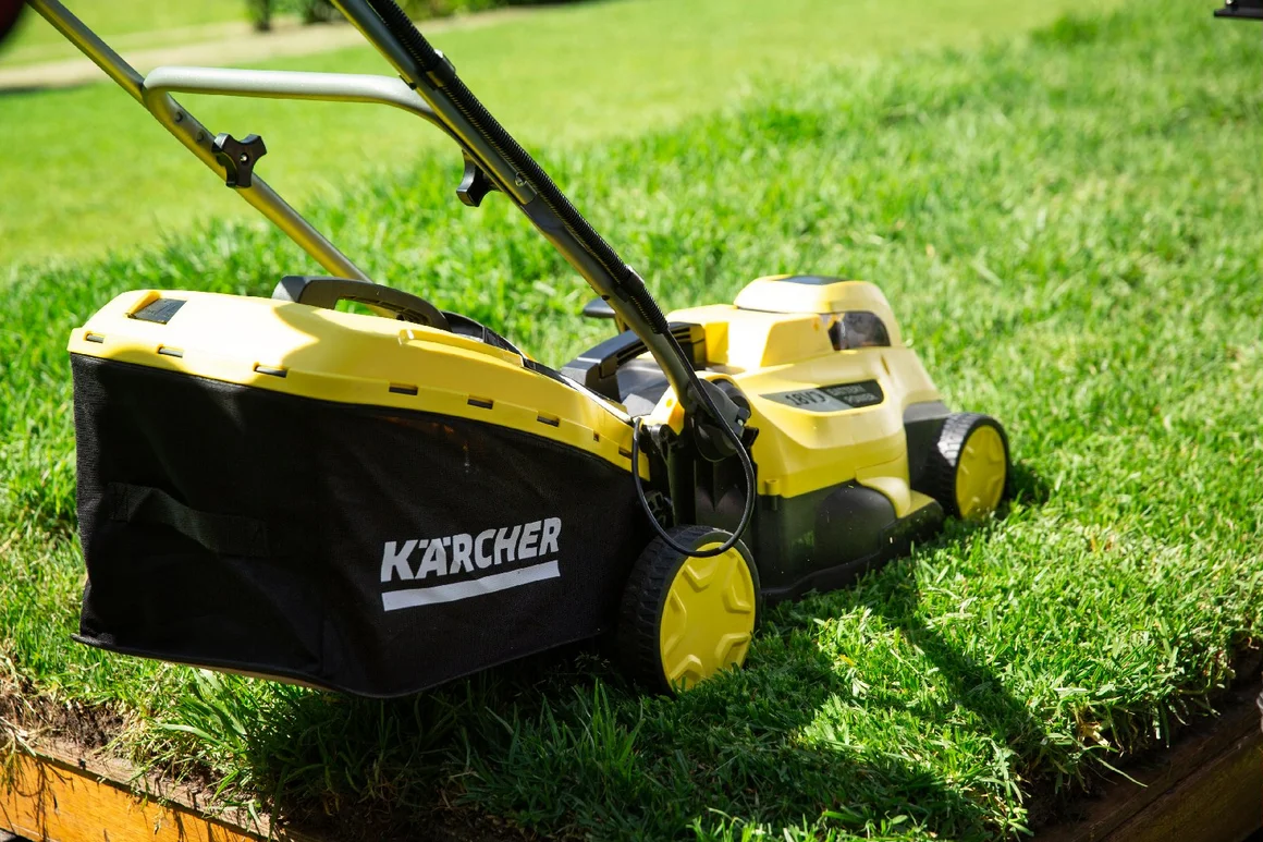 Gelber Rasenmäher auf grünem Rasen