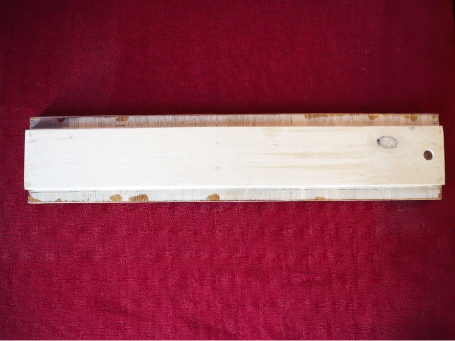 Leere Holztafel auf rotem Stoff