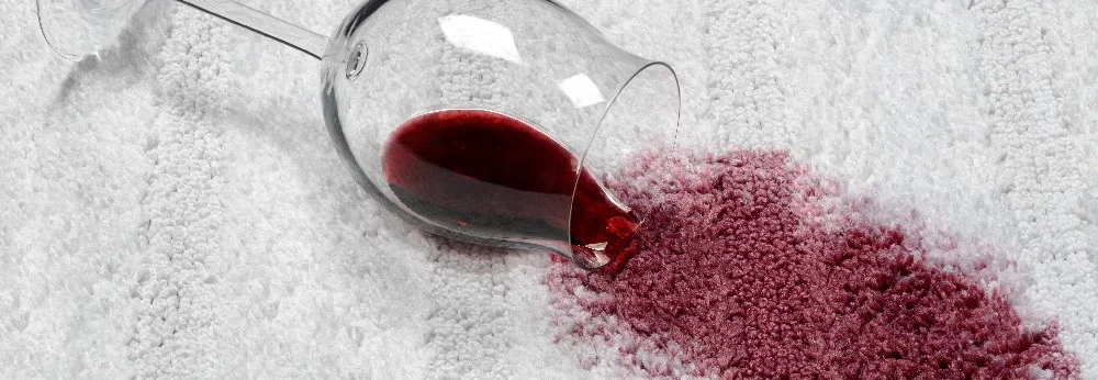 Rotweinglas auf einem Teppich verschüttet