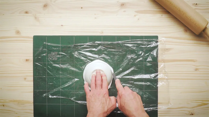 Person schneidet Folie mit Messer