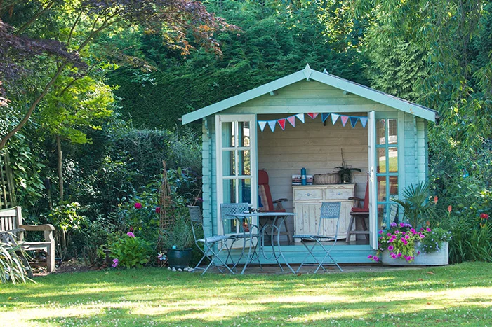 Hellblaues Gartenhaus mit Möbeln