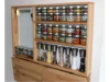 Ein aufklappbarer Gewürzschrank aus Holz mit vielen Gewürzgläsern