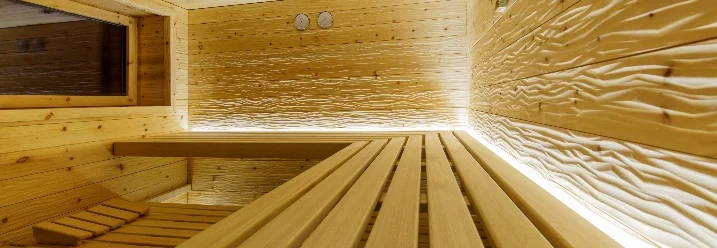 Leere Sauna aus hellem Holz mit Beleuchtung