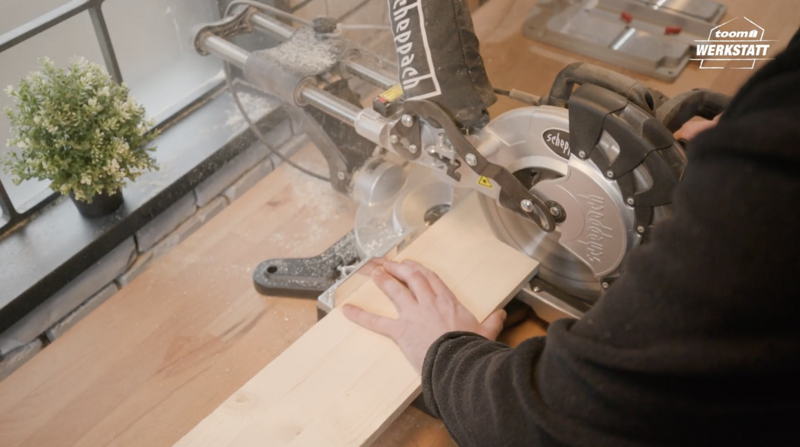 Person sägt Holz mit Kappsäge