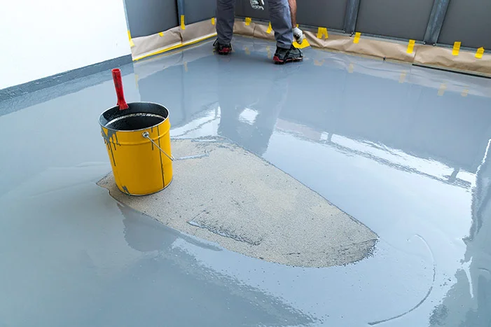 Grauer Boden mit Eimer und Kelle