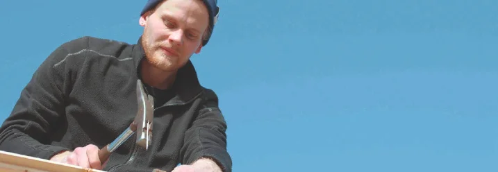 Person hämmert Holzlatten fest