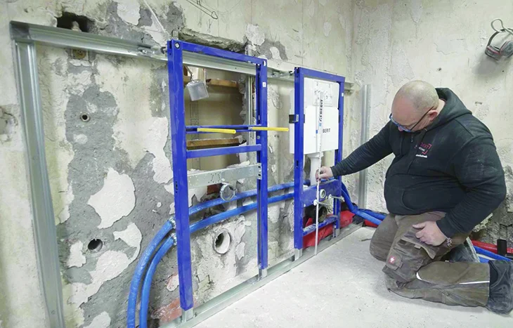 Person montiert Unterputzspülkasten