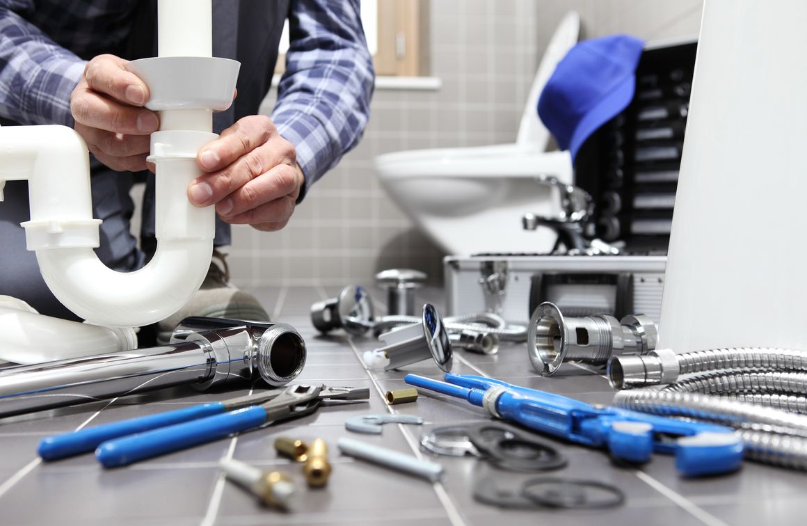 Handwerker im Bad montiert Rohr
