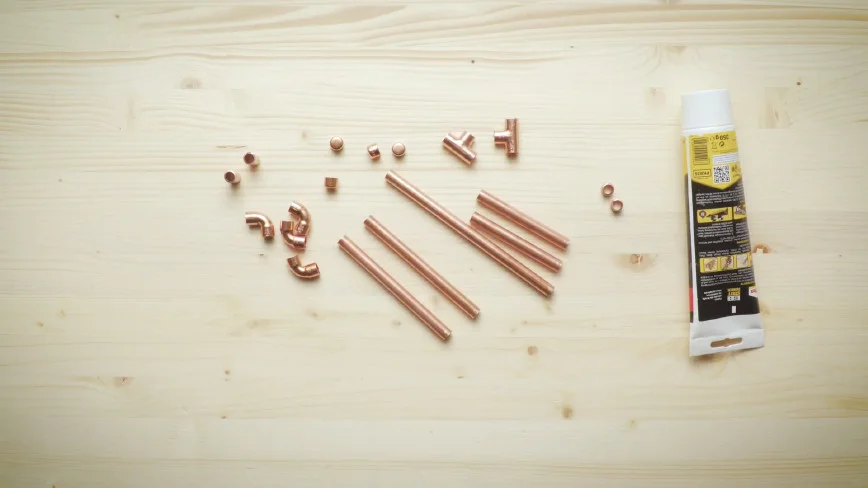 Kupferrohre und Kleber auf Holz