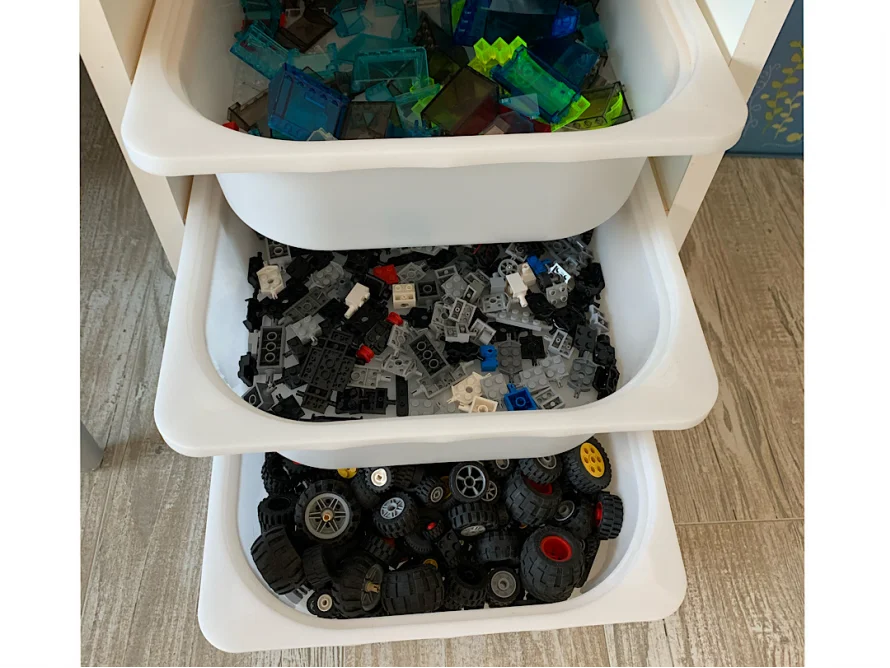 Drei Schubladen mit sortierten Legosteinen