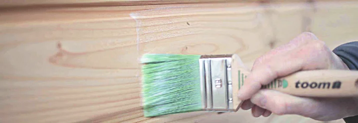 Person streicht Holz weiß