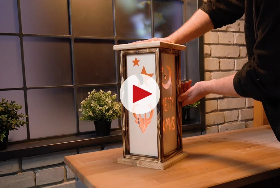 Person stellt Holzlaterne auf Tisch