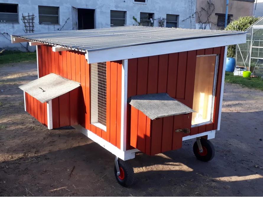 Roter mobiler Hühnerstall mit Rädern