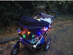Kinderwagen mit Lichterkette im Dunkeln